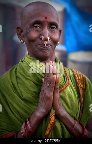 India, ritratto stupefacente di una donna pellegrina con testa calva e tilak e anello del naso su Dashashwamedh Ghat a Varanasi Foto Stock