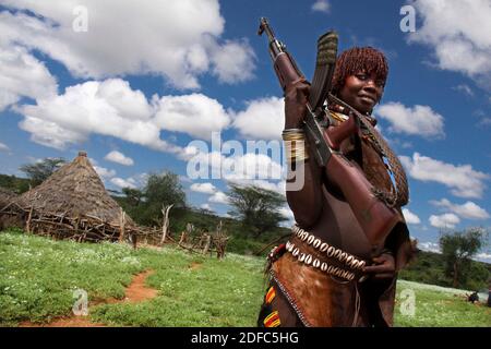 Etiopia, Valle Omo, donne etiopi della tribù Hamer che posano con una pistola vicino a Turmi Foto Stock