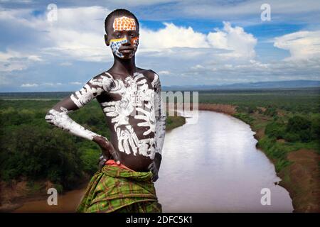 Etiopia, in posa in villaggio di fronte al fiume Omo nella valle Omo, karo giovane uomo con body painting Foto Stock