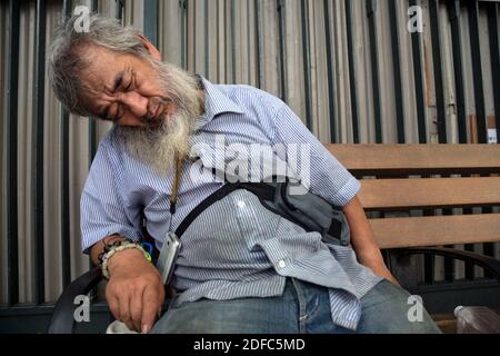 L'uomo sopportato di Hong Kong dorme in luogo pubblico Foto Stock