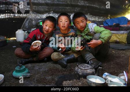 Cina, Sichuan, Tagong, i bambini tibetani nomadi mangiano nella loro tenda Foto Stock