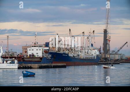 Tripoli, Libia - 25 novembre 2020: Il porto di Tripoli durante il tramonto in una normale giornata lavorativa. Foto Stock