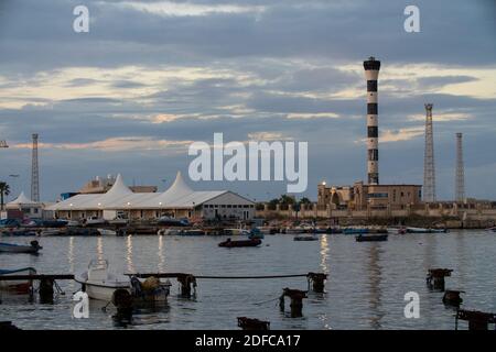 Tripoli, Libia - 25 novembre 2020: Il porto di Tripoli durante il tramonto in una normale giornata lavorativa. Foto Stock