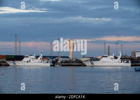 Tripoli, Libia - 25 novembre 2020: Il porto di Tripoli durante il tramonto in una normale giornata lavorativa. Foto Stock