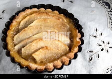 Piccola torta di mele fatta in casa su sfondo rustico Foto Stock