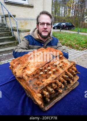 Schleswig, Germania. 04 dicembre 2020. Florian Huber, ricercatore subacqueo, si inginocchia davanti all'ufficio archeologico di Schleswig-Holstein quando consegna la macchina Enigma cifrata, che ha trovato nel Mar Baltico, accanto alla macchina. Credit: Axel Heimken/dpa/Alamy Live News Foto Stock