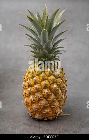 Un Pineapple posto sullo sfondo della tavola di cemento. Ananas freschi. Foto Stock