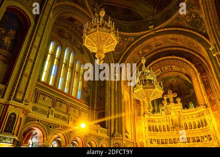 Vista dal basso su lampadari dorati appesi sul soffitto, all'interno della vecchia cattedrale ortodossa di Timisoara, Romania. Foto Stock