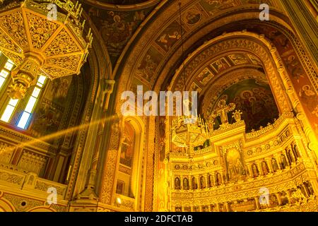 Vista dal basso su lampadari dorati appesi sul soffitto, all'interno della vecchia cattedrale ortodossa di Timisoara, Romania. Foto Stock