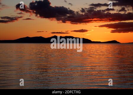 Tramonto su Arran da Prestwick Beach. Ayrshire, Scozia, Regno Unito riflessioni e lucido feel. L'isola di Arran, Scozia, Regno Unito. Conosciuto come il gigante dormiente becuase del relativo contorno particolarmente quando visto dalla costa dell'Ayrshire. Foto Stock