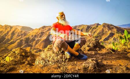 Uomo anziano saluto tramonto Foto Stock