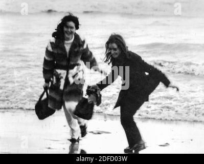 Anni '60 anni '70 mare aperto giovani amici in bianco e nero divertirsi alla spiaggia toscana di Castinglioncello. Italia. Scansione di graffi e difetti Foto Stock