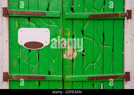 Cancello di legno verde d'epoca all'ingresso con segnaletica Foto Stock