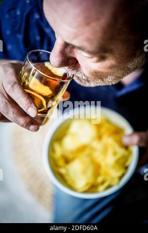 Uomo che mangia patatine. Foto Stock