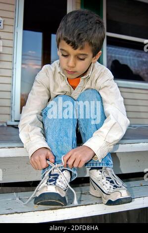 Ragazzo impara a legare la sua scarpa Foto Stock