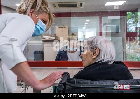 FAMIGLIE CHE VISITANO I LORO GENITORI IN UNA CASA DI RIPOSO IN CONFORMITÀ CON LE NORME SULLA DISTANZA SOCIALE DURANTE LA PANDEMIA COVID-19, EHPAD DI MALNOUE, EMERAINVILLE (77), SEINE ET MARNE, FRANCIA, EUROPA Foto Stock