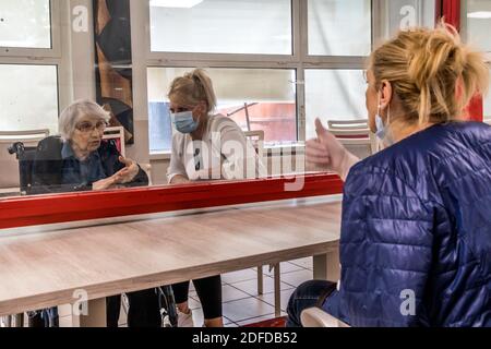 FAMIGLIE CHE VISITANO I LORO GENITORI IN UNA CASA DI RIPOSO IN CONFORMITÀ CON LE NORME SULLA DISTANZA SOCIALE DURANTE LA PANDEMIA COVID-19, EHPAD DI MALNOUE, EMERAINVILLE (77), SEINE ET MARNE, FRANCIA, EUROPA Foto Stock