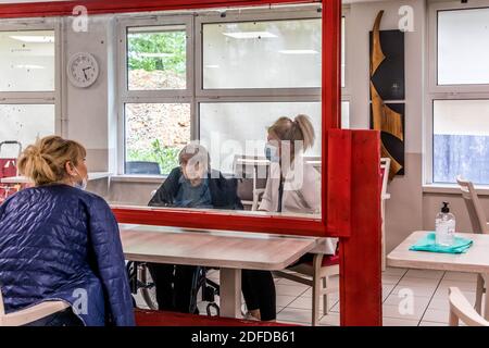 FAMIGLIE CHE VISITANO I LORO GENITORI IN UNA CASA DI RIPOSO IN CONFORMITÀ CON LE NORME SULLA DISTANZA SOCIALE DURANTE LA PANDEMIA COVID-19, EHPAD DI MALNOUE, EMERAINVILLE (77), SEINE ET MARNE, FRANCIA, EUROPA Foto Stock