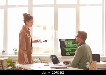 Le persone che lavorano in team in ufficio sviluppano nuovi software sui computer Foto Stock