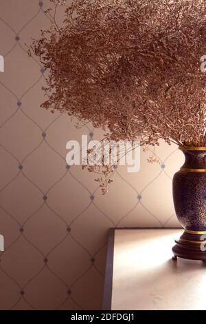 Vaso con fiori secchi sul tavolo in bella luce. Sfondo minimalista Foto Stock