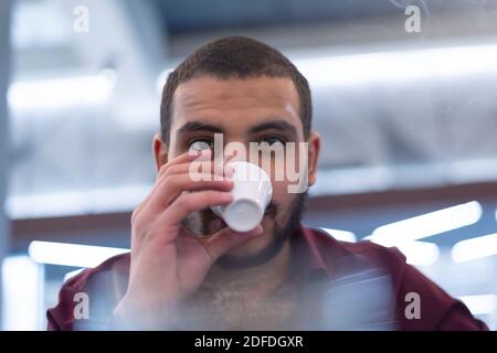 Rilassante Young African Man bere caffè, all'aperto Cafe Foto Stock