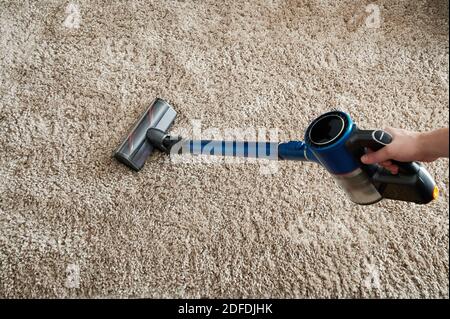 Tema del servizio di pulizia della casa. Moquette per la pulizia dei lavoratori con aspirapolvere Foto Stock