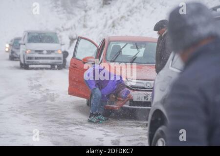 Mamor Tor, Regno Unito. 4 Dicembre 2020. Una donna cerca di riparare la sua auto vicino a Mamor Tor dopo una nevicata la scorsa notte. Credit: Joannis Alexopoulos/Alamy Live News Foto Stock