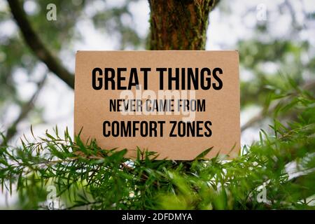 Citazione motivazionale e motivazionale. Le cose grandi non sono mai venute da Comfort Zones. Scheda di carta sulla natura. Foto Stock