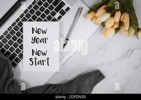 Nuovo anno, nuovo inizio. Preventivo motivazionale e motivazionale su carta con notebook sulla scrivania. Foto Stock