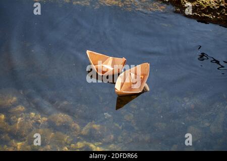 Due barche di carta in acqua Foto Stock