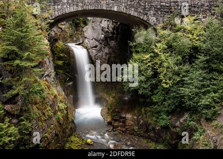 Christine Falls cascata incorniciata da ponte e alberi in Mt Parco nazionale Rainier Foto Stock