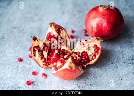 Primo piano di melograno maturo e semi sul banco di cemento. Foto Stock