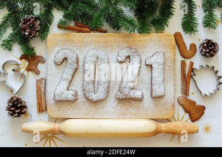 Figure di pan di zenzero. 2021 iscrizione. Vista dall'alto. Il layout di Capodanno. Scritta di Capodanno tra abeti e biscotti Foto Stock