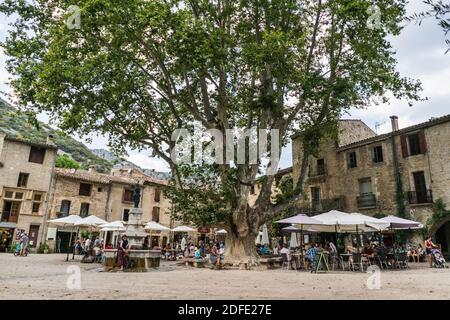 Gente locale e turisti nella piazza principale del Saint-Guilhem-le-Désert, Languedoc-Roussillon, Francia, Europa. Foto Stock