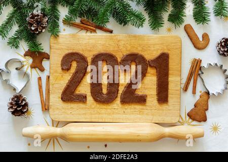 Figure di pan di zenzero. 2021 iscrizione. Vista dall'alto. Il layout di Capodanno. Scritta di Capodanno tra abeti e biscotti Foto Stock