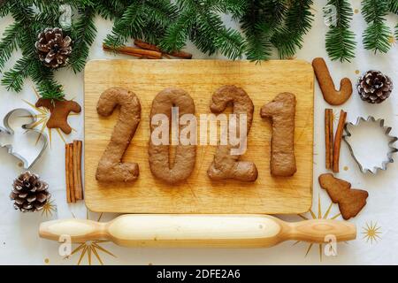 Figure di pan di zenzero. 2021 iscrizione. Vista dall'alto. Il layout di Capodanno. Scritta di Capodanno tra abeti e biscotti Foto Stock