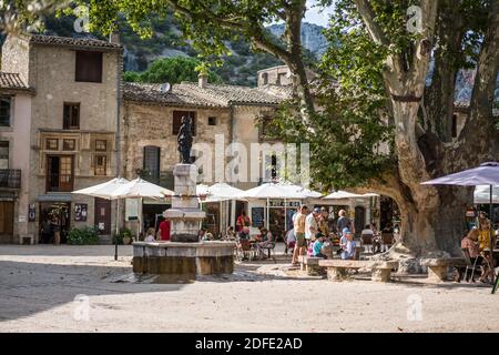 Gente locale e turisti nella piazza principale del Saint-Guilhem-le-Désert, Languedoc-Roussillon, Francia, Europa. Foto Stock