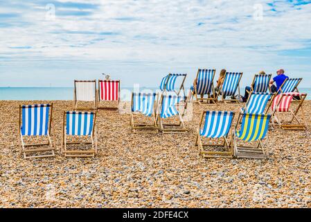 Tipica estate inglese. Sdraio sulla spiaggia di ciottoli. Brighton, East Sussex, Inghilterra, Regno Unito, Europa Foto Stock