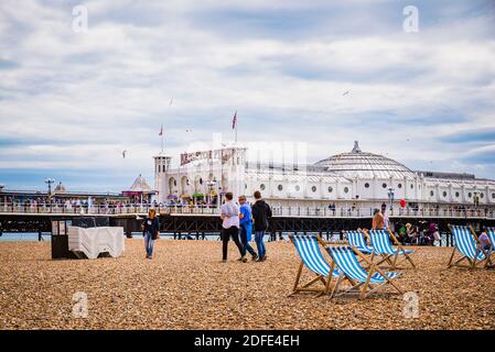 Persone in spiaggia vicino al molo di Brighton. Brighton, East Sussex, Inghilterra, Regno Unito, Europa Foto Stock