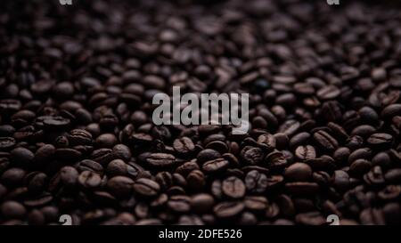 Chicchi di caffè sparsi close-up.grani di caffè arrosto, appetitoso, germogli di fagioli profumati. Foto Stock