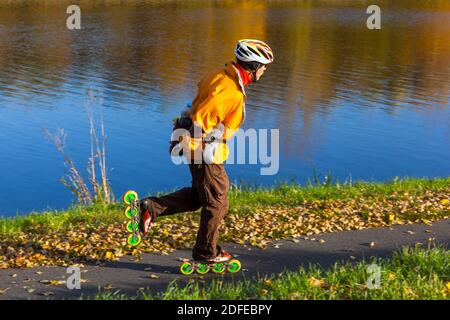 Uomo anziano pattinaggio a rotelle lungo il fiume stile di vita sano persona anziana Foto Stock