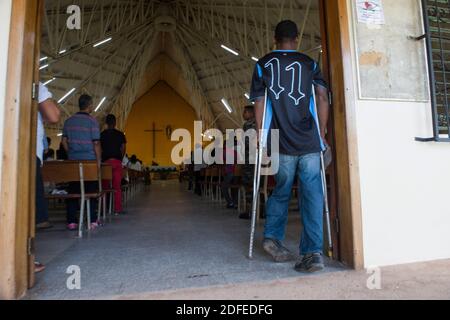 La persona disabile paralizzò dalla malattia di decompressione (DCS) a causa di intensa pesca di aragosta con metodi di immersione subacquea, entrando in una chiesa per la Santa messa. Puerto Lempira, Mosquitia, Honduras Foto Stock