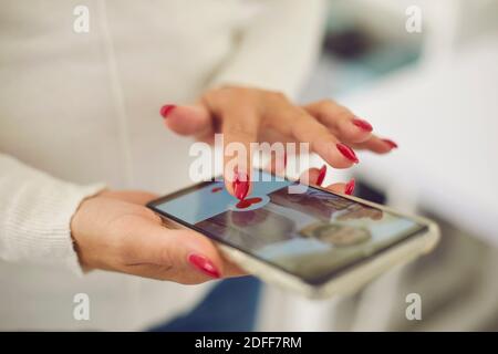 Mani di giovane femmina che sceglie il ragazzo o il possibile marito dentro applicazione di datazione online Foto Stock