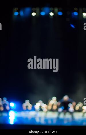 Texture offuscare scena luci multicolore e fumo in concerto con le sagome della gente. Sfondo per design, texture sfocata, attori sul palco. Foto Stock