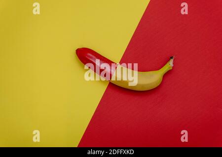Metà banana rossa su sfondo bicolore. Disposizione piatta. Concetto di cibo minimo Foto Stock