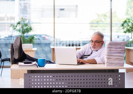 Il vecchio dipendente dell'uomo d'affari non è soddisfatto del lavoro eccessivo Foto Stock