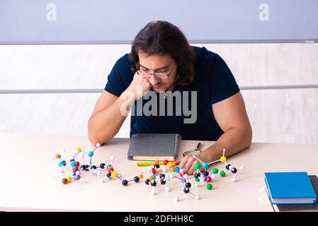 Giovane scienziato seduto in classe Foto Stock