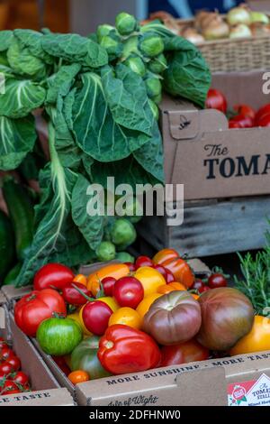 una varietà di pomodori colorati in vendita su una bancarella di mercato che vende frutta e verdura fresche. Foto Stock