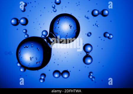 Rendering 3d: Astratte le molecole di idrogeno H2 davanti allo sfondo blu vignettato Foto Stock