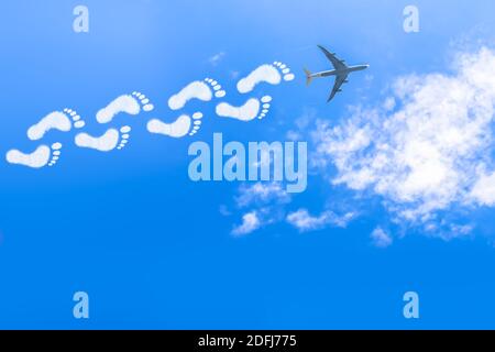 Le nuvole a forma di impronte formano i percorsi di condensazione Di un jet Airliner Foto Stock